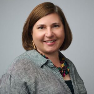 photo of Kate Travis, a white woman with shoulder-length brown hair